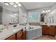 Main bathroom featuring dual sinks, vanity, garden tub, and decorative window at 503 Belmont Cir, Wake Forest, NC 27587