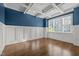 Room with hardwood floors, wainscoting, blue walls, a coffered ceiling, and large windows at 503 Belmont Cir, Wake Forest, NC 27587