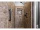 Walk-in shower featuring stylish brown tile with built-in shelving and shower bar at 503 Belmont Cir, Wake Forest, NC 27587