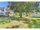 Spacious backyard with a mature shade tree, manicured lawn and home with white siding at 506 S King Ave, Dunn, NC 28334