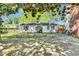 View of the backyard featuring a white outbuilding, shade trees, and partial brick patio at 506 S King Ave, Dunn, NC 28334