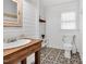 Stylish half bathroom featuring a decorative floor, wood vanity, and shiplap walls at 506 S King Ave, Dunn, NC 28334