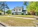 A two-story home has a brick-lined walkway leading to a charming front door, complemented by lush greenery at 506 S King Ave, Dunn, NC 28334