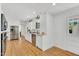 Bright kitchen with stainless steel appliances, white cabinetry and wood flooring at 506 S King Ave, Dunn, NC 28334