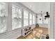 Sunroom filled with natural light featuring white wood paneling, hardwood floors, and multiple windows at 506 S King Ave, Dunn, NC 28334