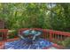 Outdoor deck featuring dining set, red railing, and tranquil greenery in the background at 508 E Trinity Ave, Durham, NC 27701