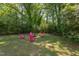 Inviting backyard with lush greenery and pink Adirondack chairs around a cozy fire pit at 508 E Trinity Ave, Durham, NC 27701