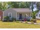 Charming home featuring a well-manicured front lawn with mature trees, landscaping, and a welcoming front porch at 508 E Trinity Ave, Durham, NC 27701