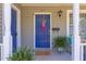 Close-up of a vibrant blue front door with a decorative wreath, potted plants, and traditional hardware at 508 E Trinity Ave, Durham, NC 27701