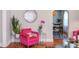 Cozy living room area with stylish pink chair, hardwood floors, and open dining room at 508 E Trinity Ave, Durham, NC 27701