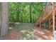 A treed backyard with a wooden stairway and stone path is covered with pine needles at 5420 Vista View Ct, Raleigh, NC 27612