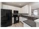 Well-lit kitchen with white cabinets, black appliances, and a functional layout at 5420 Vista View Ct, Raleigh, NC 27612