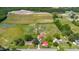 Expansive aerial view of a property featuring lush fields, a pond, and several well-maintained houses with vibrant green surroundings at 5423 Nc-39, Selma, NC 27576