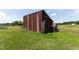 Exterior view of barn on beautiful property with lush green grass and plenty of open land and trees at 5423 Nc-39, Selma, NC 27576