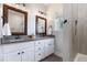 Bathroom with double sinks, granite countertop, stylish mirrors, and a tile-enclosed shower at 5423 Nc-39, Selma, NC 27576