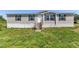 Exterior front view of a manufactured home with a lawn and wooden stairs to the front door at 5423 Nc-39, Selma, NC 27576