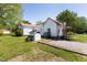 Quaint home exterior featuring a red roof, well-maintained lawn, and gravel driveway at 5423 Nc-39, Selma, NC 27576