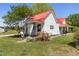 Quaint home featuring a vibrant red metal roof, tidy landscaping, and an inviting front porch with stylish details at 5423 Nc-39, Selma, NC 27576