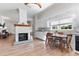 Spacious kitchen featuring a brick fireplace, white cabinetry, and wood-look flooring, blending classic charm with modern amenities at 5423 Nc-39, Selma, NC 27576