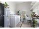 Bright laundry room featuring modern appliances, utility sink, storage shelves, and natural light at 5423 Nc-39, Selma, NC 27576