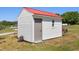 New outbuilding with white siding and a red roof on a green lawn in a rural landscape at 5423 Nc-39, Selma, NC 27576
