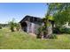 Rustic wooden outbuilding surrounded by lush greenery, offering storage or workshop potential at 5423 Nc-39, Selma, NC 27576