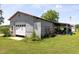 View of a metal outbuilding with a red roof, featuring a garage door and an open-air workshop area at 5423 Nc-39, Selma, NC 27576