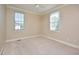A neutral bedroom featuring carpet, white trim, and two sunny windows at 55 Derwin Dr, Timberlake, NC 27583