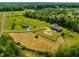 Expansive aerial view of property featuring the home, barn, pastures and lush green acreage at 5916&5918 Laws Farm Rd, Rougemont, NC 27572