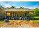 Exterior shot of the back of the house with a covered patio, garbage cans, and a fenced yard at 5916&5918 Laws Farm Rd, Rougemont, NC 27572