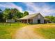 Barn with stalls, covered area, gravel driveway and adjacent yard, a versatile space for equestrian use at 5916&5918 Laws Farm Rd, Rougemont, NC 27572