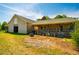 Tan barn featuring a covered porch, wood piles, and an open yard at 5916&5918 Laws Farm Rd, Rougemont, NC 27572
