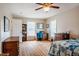 Sunny bedroom with a ceiling fan, hardwood floors, and a matching wooden desk at 5916&5918 Laws Farm Rd, Rougemont, NC 27572