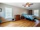 Comfortable bedroom with hardwood floors, a ceiling fan, and a built-in bookshelf at 5916&5918 Laws Farm Rd, Rougemont, NC 27572