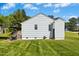 View of the side of the house, featuring a well-kept lawn, grill, and a peaceful outdoor setting at 624 Wait Ave, Wake Forest, NC 27587