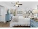 Bright bedroom with a queen-sized bed, blue dressers, and a ceiling fan at 624 Wait Ave, Wake Forest, NC 27587