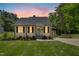 Charming home with a lush front lawn, an American flag, inviting walkway, and warm window lighting at 624 Wait Ave, Wake Forest, NC 27587