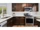 Modern kitchen featuring stainless steel appliances, dark cabinetry, and bright white backsplash at 624 Wait Ave, Wake Forest, NC 27587