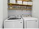 Laundry room featuring a washer, dryer, and floating shelves with basket storage at 624 Wait Ave, Wake Forest, NC 27587