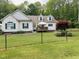 Inviting home featuring a charming front yard with well-manicured lawn and a black chain link fence at 67 Bull Run N, Timberlake, NC 27583