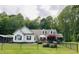 Charming home with white siding, green shutters, well-manicured lawn, and a fenced yard at 67 Bull Run N, Timberlake, NC 27583