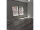 Bedroom featuring wood-look floors and a pair of windows overlooking the backyard at 7 Mint Hill Ct, Durham, NC 27703
