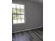 Bedroom featuring wood-look floors, a large window for ample natural light, and neutral paint at 7 Mint Hill Ct, Durham, NC 27703