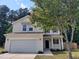 Charming two-story home with vinyl siding, attached two-car garage, and a tree in the front yard at 7 Mint Hill Ct, Durham, NC 27703