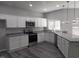 Modern kitchen with stainless steel appliances, granite countertops, white cabinets, and pendant lighting at 7 Mint Hill Ct, Durham, NC 27703