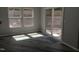 Bright living room with wood-look floors, large windows, and sliding glass door to the backyard at 7 Mint Hill Ct, Durham, NC 27703