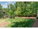 Green backyard with manicured lawn, bushes, and trees at 7108 Carries Reach Way Way, Raleigh, NC 27614