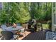 Back deck features a dining table and grill with wooded views at 7108 Carries Reach Way Way, Raleigh, NC 27614