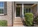 Charming entryway with brick steps, black iron railing, and lush greenery, creating a welcoming curb appeal at 7108 Carries Reach Way Way, Raleigh, NC 27614