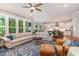 Spacious living room featuring a large sectional sofa, ceiling fan, and seamless view to kitchen at 7108 Carries Reach Way Way, Raleigh, NC 27614